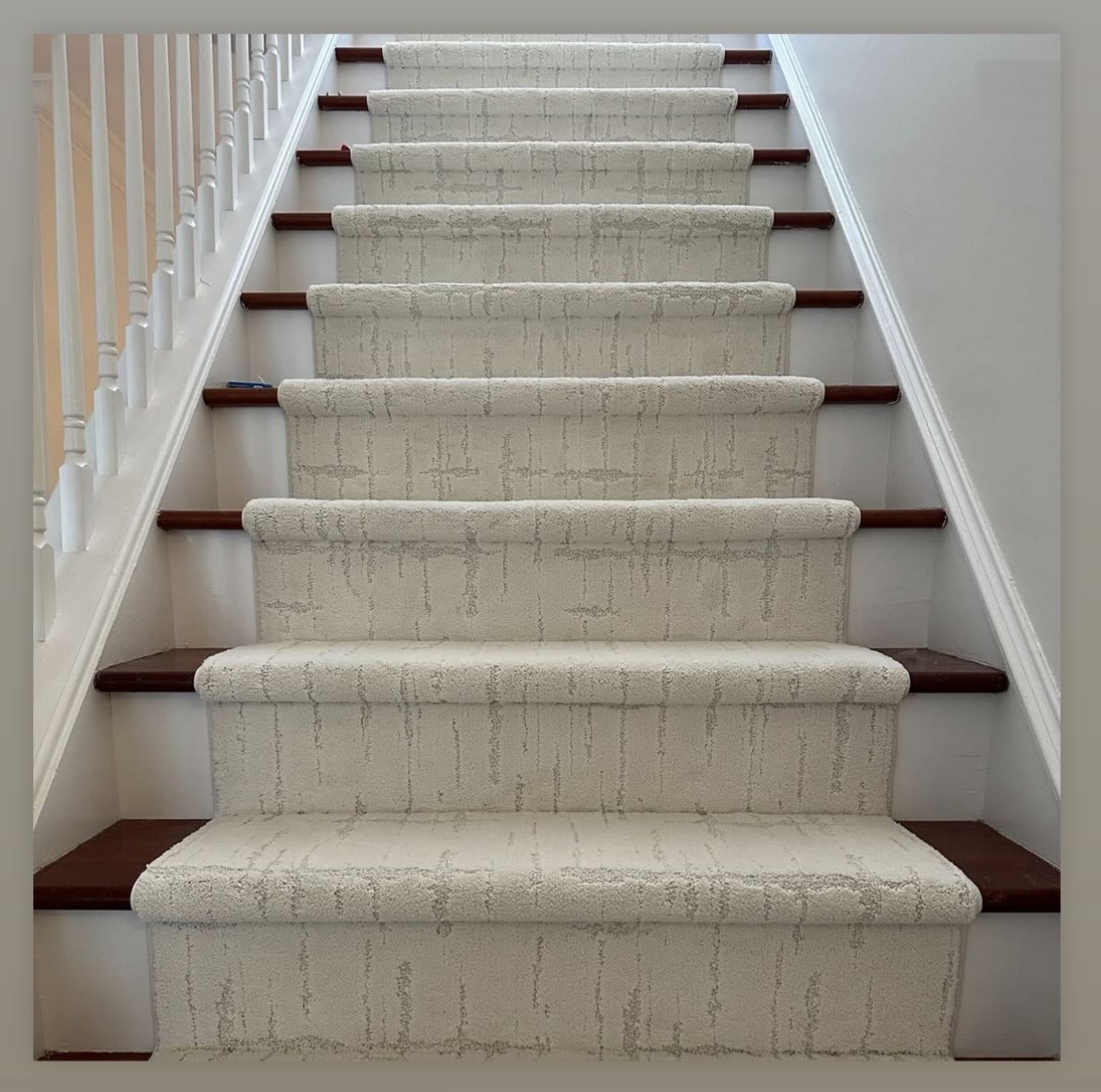 Custom light-patterned stair runner fitted to dark wood stairs