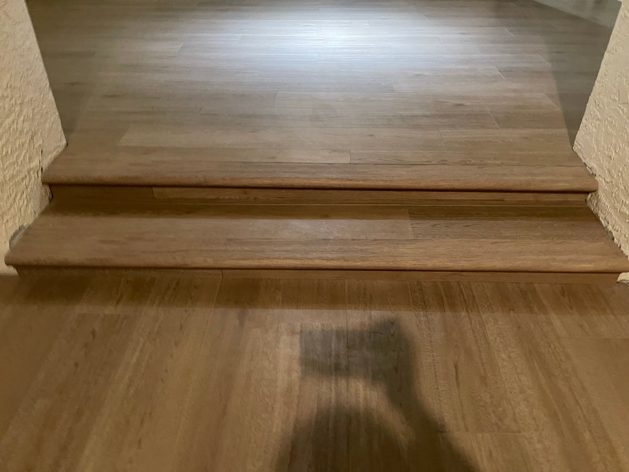 Custom luxury vinyl step transition coordinated with adjoining flooring