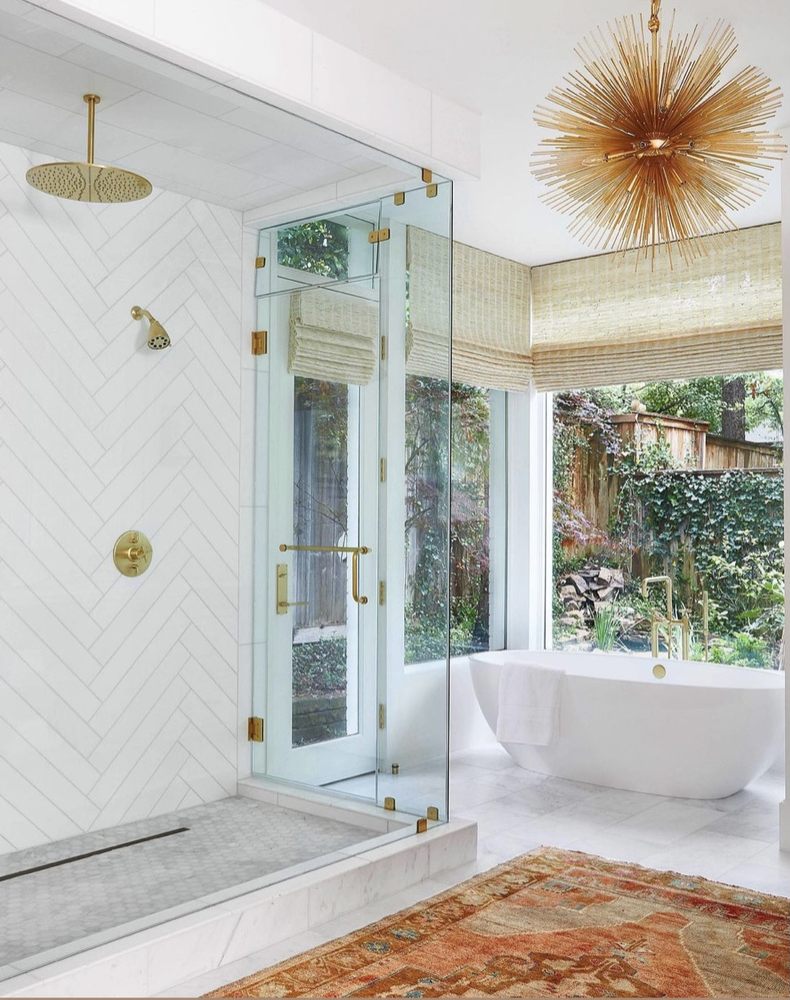 Light-filled luxury bathroom with glass shower and freestanding tub